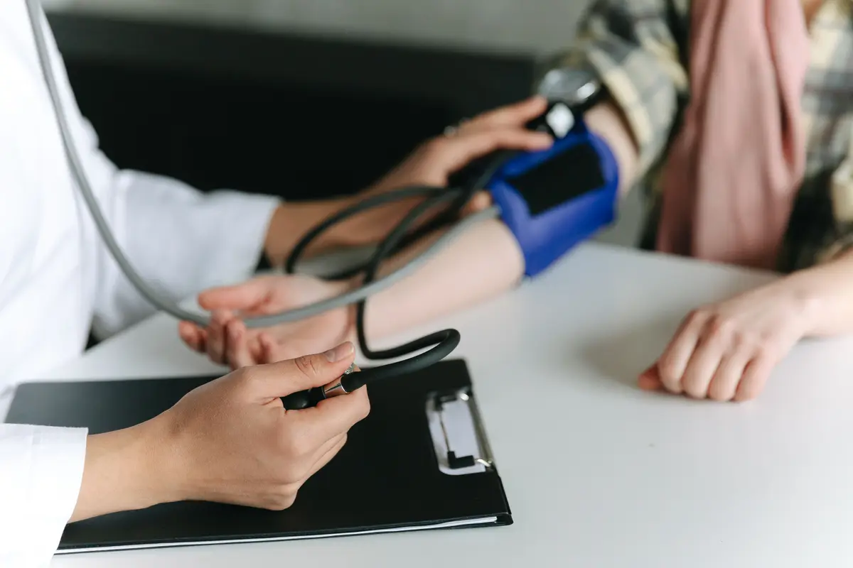 Profesional de enfermería tomando la presión arterial a una paciente